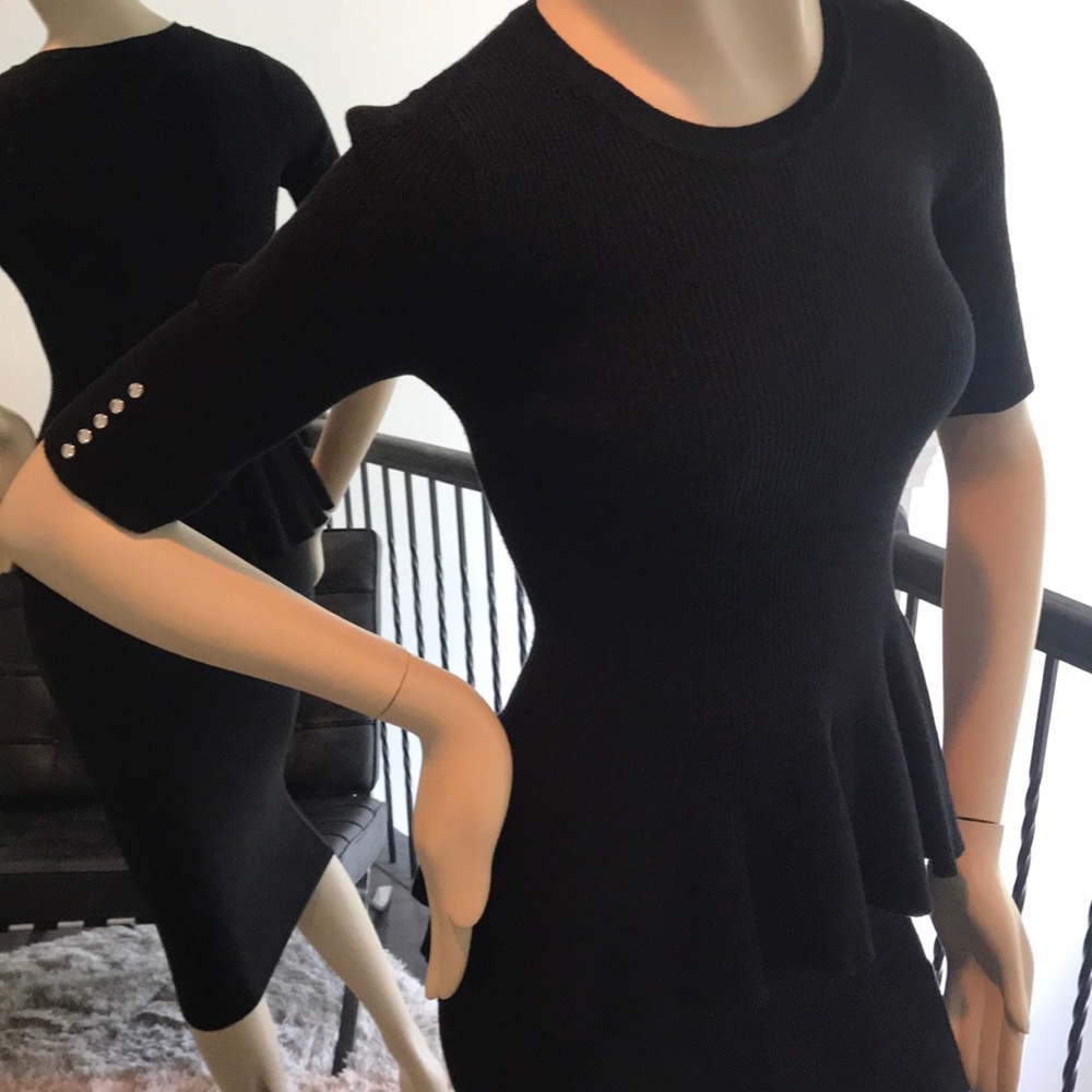 Black, short-sleeve, knit top with peplum.